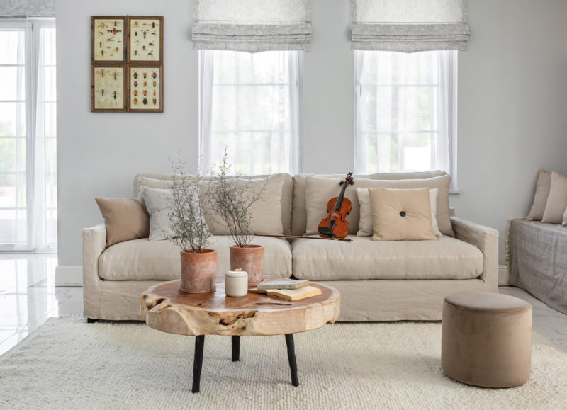DALLAS sofa with coffee table and footstool, designed with accessories and a violin in the sofa.