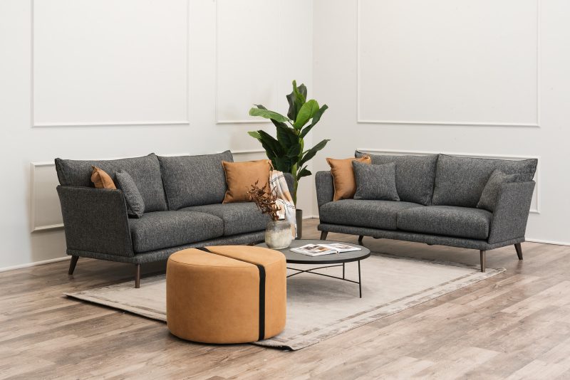 Two PEPPER sofas in pegiant color with footstool and furnished accessories.